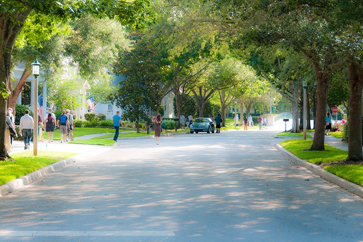 people walking the shady streets of Celebration, Florida on a sunny spring morning