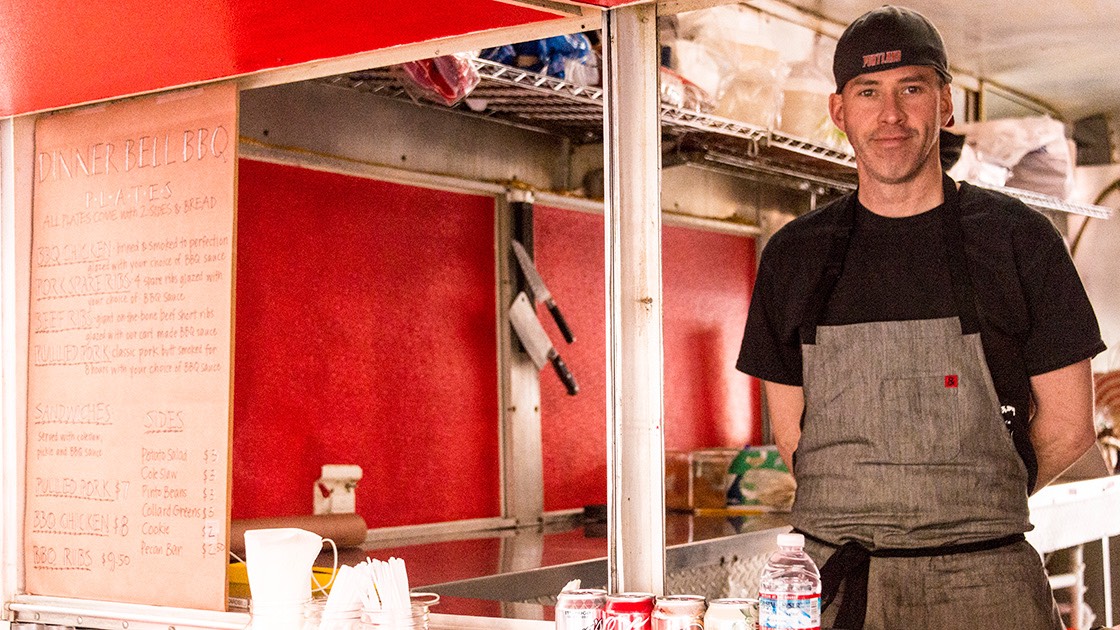Sam Mouzon inside his Dinner Bell Barbecue food cart in Portland, Oregon, moments after opening for the first time