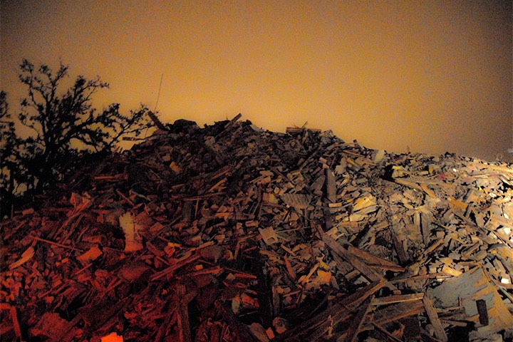 mountain of rubble in Gulfport, Mississippi glows eerily in evening light in the wake of Katrina