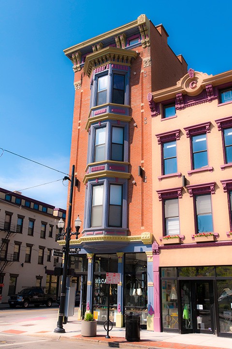 colorful corner store in Cincinnati's Over-The-Rhine neighborhood reaches to the sky with three bay-fronted levels above