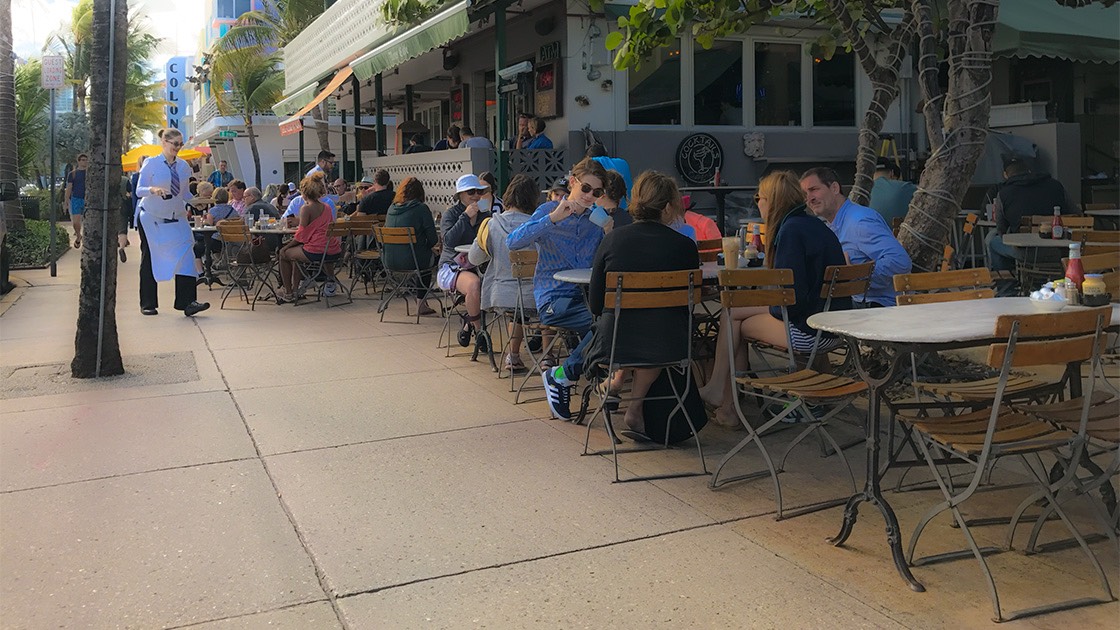 late morning crowd enjoying breakfast at the News Cafe on South Beach's Ocean Drive, just across from Lummus Park